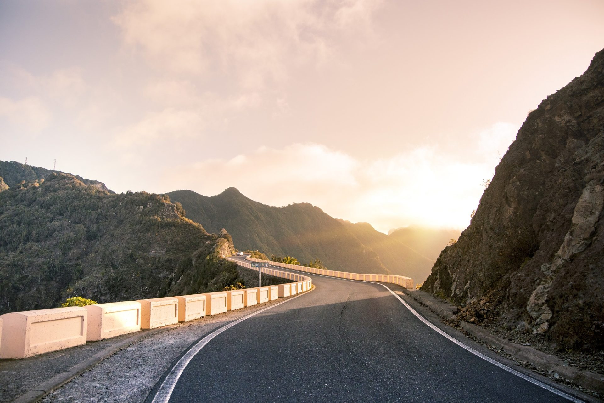 Travel background of highway in Anaga mountains with sunset rays. Canary Islands, Spain - March 15 2020